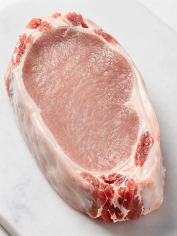 Ahşap kesme tahtasında baharatlarla taze dana eti parçaları