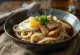 Kasede servis edilen Stamina udon, kavrulmuş tavuk eti, yumurta ve soya soslu sos ile