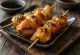 Tavuk derisi ile Kawa yakitori, susam ve yeşil soğanla süslenmiş