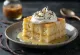 Vanilyalı tres leches dilimi, sütle ıslatılmış pandispanya beyaz tabakta