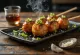 Tsukune yakitori, şişte tavuk köfteleri, susam ve taze soğanla servis edilmiş